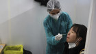 A passenger arriving from China is tested for COVID-19 at Roissy Charles de Gaulle airport in Paris.