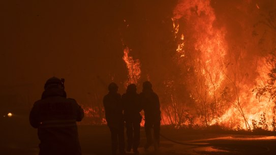 Safety issues: A firefighter is assisted seconds after being hit in thick smoke as fire roared through eastern Bilpin in the Blue Mountains in December.
