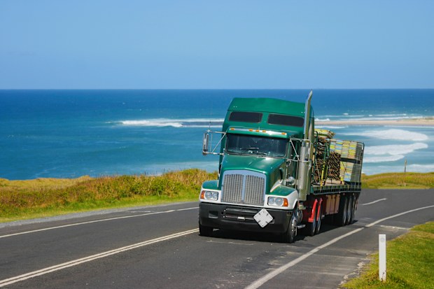Semi trailer truck driving by the ocean