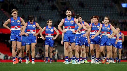 Skipper Marcus Bontempelli leads the bedraggled Bulldogs off Marvel Stadium, with their finals prospects hinging on the slim hope Essendon can beat Gold Coast.