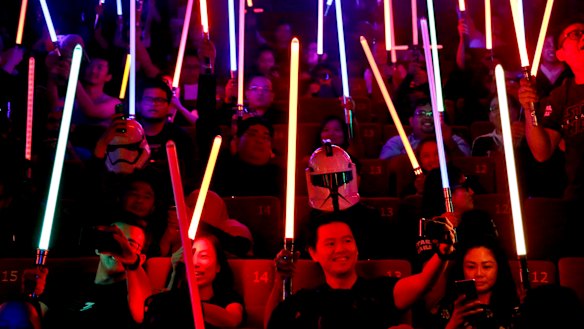 Epic fandom: Star Wars fans raise their lightsabers before the starts of Star Wars: The Last Jedi movie.