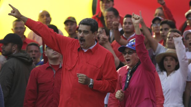 Venezuelan leader Nicolas Maduro, centre left, and his wife Cilia Flores, centre right, wave at supporters during a rally in Caracas on May 1.