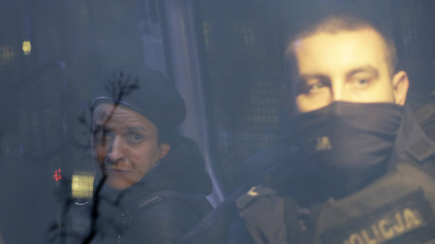 Agata Grzybowska, left, a photojournalist, is detained by police in Warsaw, Poland.