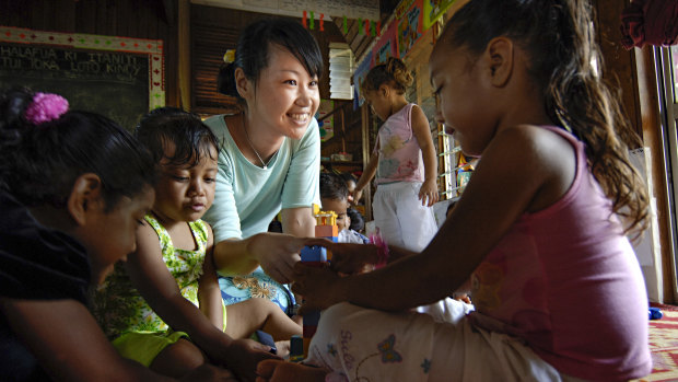A Japanese aid worker with children on the Pacific island of Tonga. 