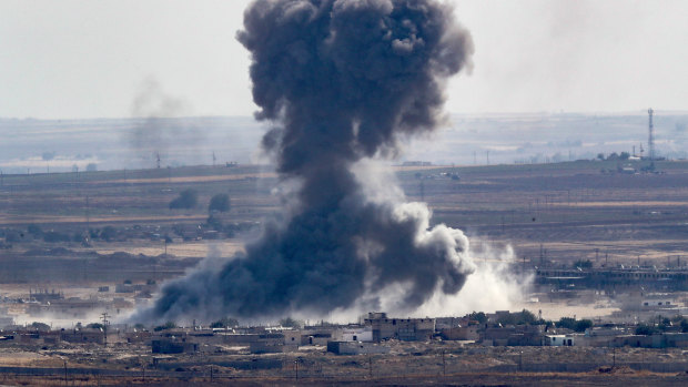Smoke rising over the Syrian town of Ras al-Ain as Turkey presses on with its military campaign in Syrian territory.