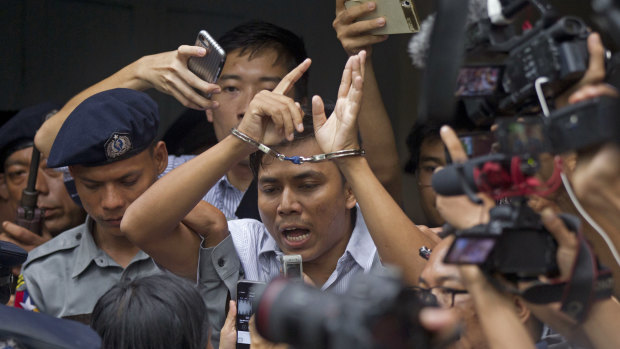 Reuters journalist Kyaw Soe Oo is escorted by police as they leave the court on Monday. He faces seven years in jail.