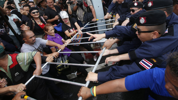 Thai pro-democracy protesters confront with riot police during a gathering marking the fourth anniversary of the military takeover in Bangkok on Tuesday.