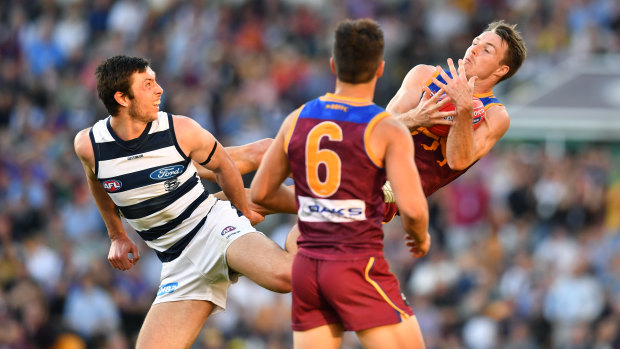 Lincoln McCarthy (right) of the Lions takes a mark over Jack Henry (left) of the Cats during the round 22 match against  Geelong at the Gabba.