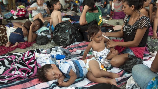 A group of migrants rests at the central park in Ciudad Hidalgo, Mexico, on Satuday.