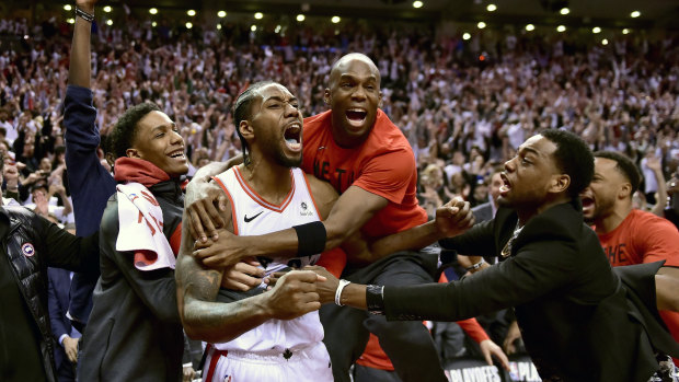 Dagger: Kawhi Leonard is mobbed by teammates after his incredible shot to clinch the series against Philadelphia.
