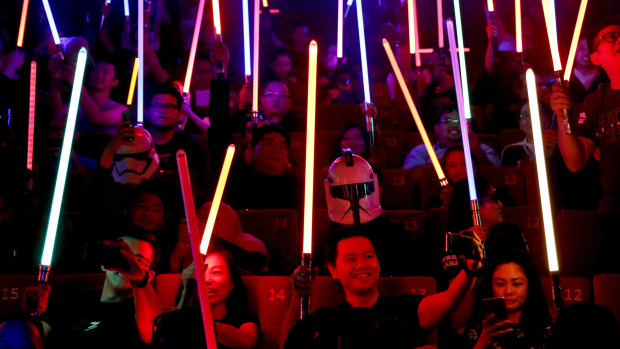 Epic fandom: Star Wars fans raise their lightsabers before the starts of Star Wars: The Last Jedi movie.