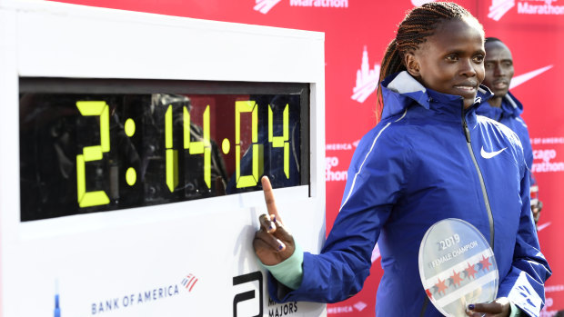 Brigid Kosgei of Kenya poses with her time after winning the Chicago Marathon while setting a world record.