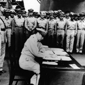 General Douglas MacArthur signs  Japan’s formal surrender documents aboard the battleship USS Missouri.  
