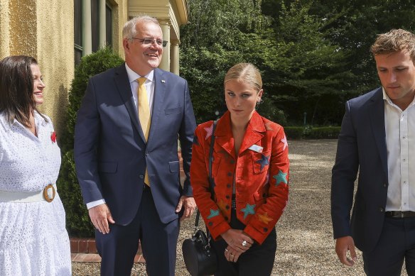 2021 Australian of the Year Grace Tame sends a message to Scott Morrison, as she poses with her partner Max Heerey and Jenny Morrison.