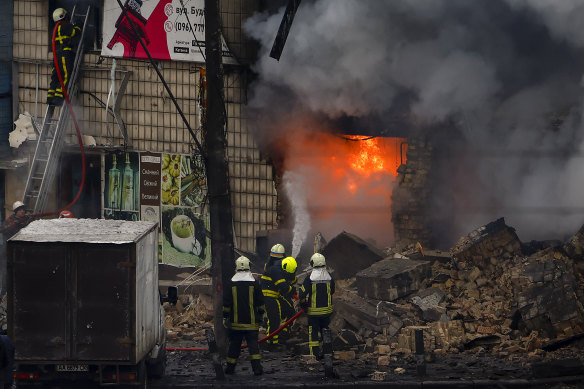 Fire and rescue workers attend a building hit by a missile in central Kyiv on November 23, 2022 in Kyiv, Ukraine. 