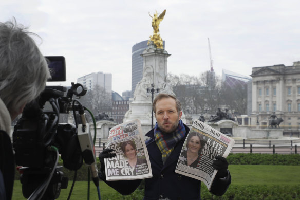 Royal coverage is a core part of British media, as shown by a reporter holding front pages in 2021 outside Buckingham Palace.