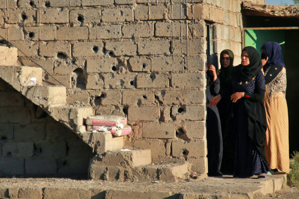 Women inspect the aftermath of a katyusha rocket attack near international airport in Baghdad, Iraq.