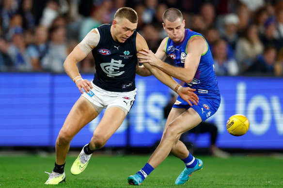 Bulls at a gate: Patrick Cripps and Bailey Scott battle for possession on Friday evening.