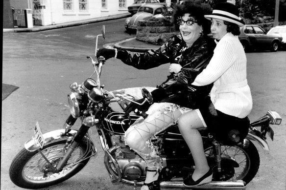 Dame Edna Everage arrives at the Sebel Town House in 1978 with her bridesmaid, marking Madge’s first public appearance.