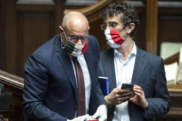 MPs Fabio Rampelli, left, and Galeazzo Bignami wear face masks in the colours of the Italian flag to protect themselves against the spread of COVID-19.