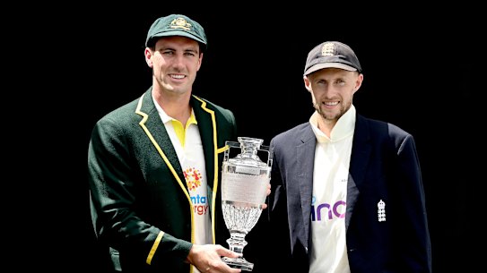Australian captain Pat Cummins and England captain Joe Root pose up with an Ashes trophy.