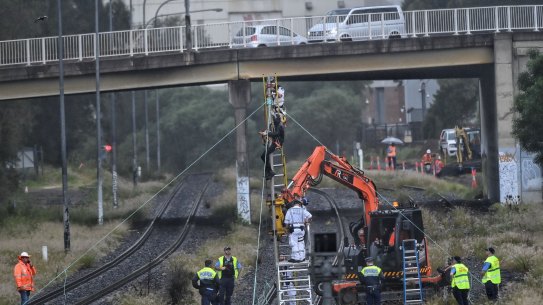 Protestors tied to a pole push for climate change action on a cargo train line near Port Botany in Pagewood on March 24.