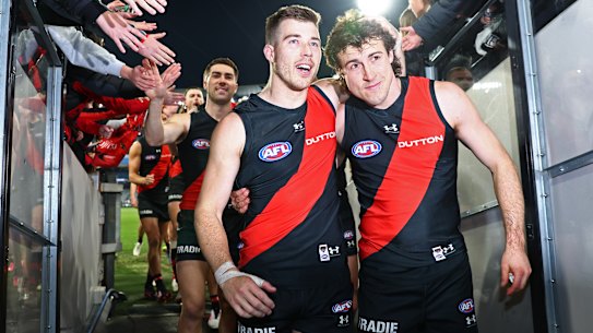 Zach Merrett walks off the MCG arm-in-arm with deputy Andy McGrath.
