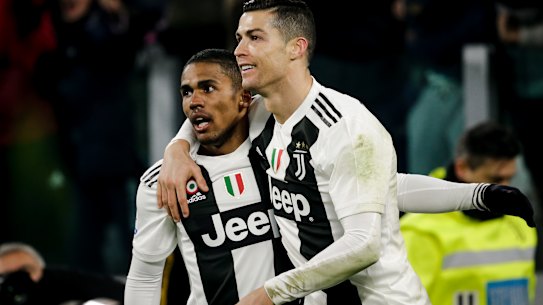 Douglas Costa celebrates with Cristiano Ronaldo during his time at Juventus.
