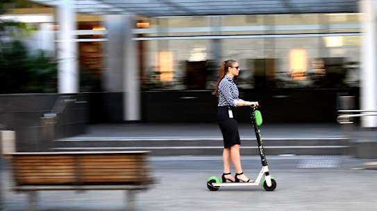  Lauren Barea, project manager at technology one rides on an e-scooter in her business attire and heels on 18th September 2019 in Brisbane, Australia.