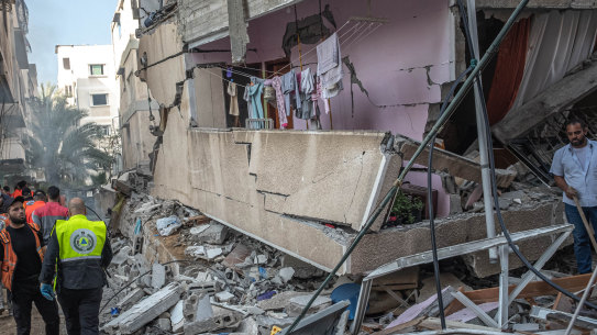 Palestinian civil defence members search for people in the rubble of a destroyed building after an Israeli air strike in Gaza City on May 16.