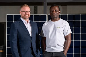 Venergy Solar CEO Matthew Wilkins and project coordinator John Obeya inside the warehouse.