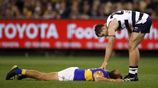 Tom Hawkins checks on Will Schofield after an incident off the ball.