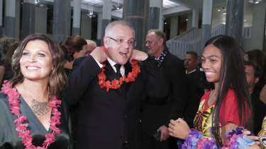 Prime Minister Scott Morrison and wife Jenny don garlands as they arrive at the Midwinter Ball.