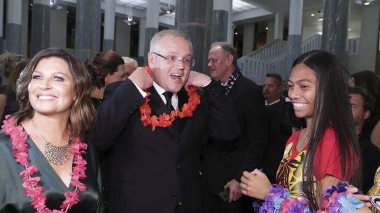 The Prime Minister Scott Morrison and wife Jenny don garlands as they arrive at the Midwinter Ball.