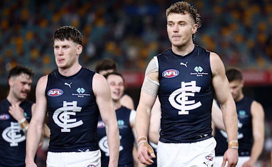 Carlton leaders Sam Walsh and Patrick Cripps lead the dejected Blues off the Gabba.