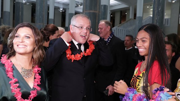 Prime Minister Scott Morrison and wife Jenny don garlands as they arrive at the Midwinter Ball.