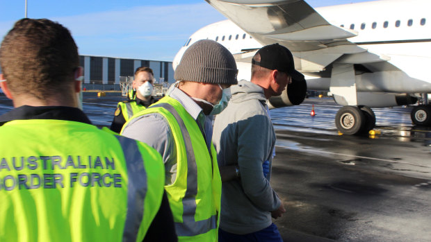Australian Border Force officers escort convicted murderer Christopher Clark Jones to a plane.