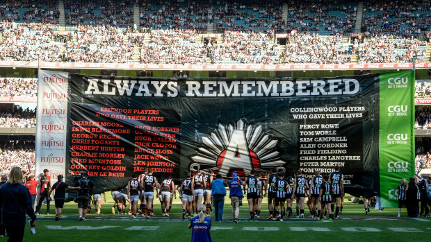 The teams go through the joint banner. 