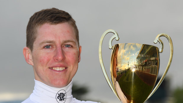Damian Lane poses with the Caulfield Cup after his victory on Mer De Glace.