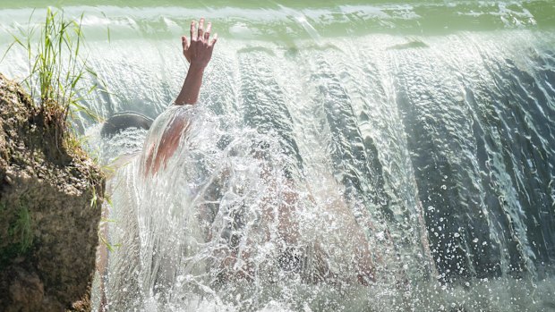 Kids cool down in a stream in the English Garden in Munich, Germany.