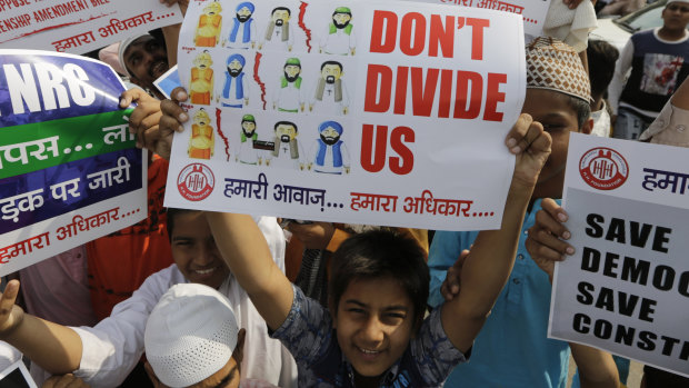 An Indian Muslim boy holds a placard during a protest against Citizenship Amendment Bill.