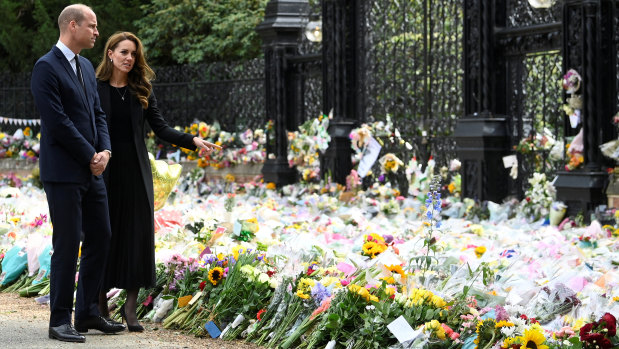 Prince William and Catherine, the Princess of Wales, inspect the flowers left at Sandringham.