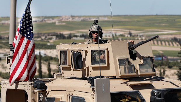 An American soldier sits in an armoured vehicle near the tense front line with Turkish-backed fighters, in Manbij, north Syria, on Wednesday.