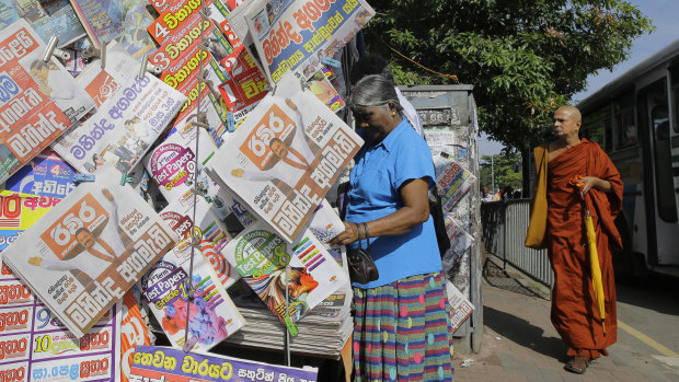 A newspaper stand shows headlines about the appointment of Mahinda Rajapaksa as the new Prime Minister.