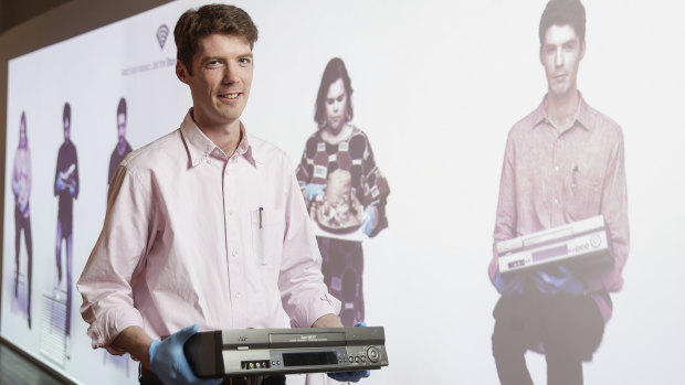 Video preservation specialist Richard Vorobieff shows off an old VCR at a new interactive display area featuring experts with various other exhibits at the National Film and Sound Archive in Canberra.