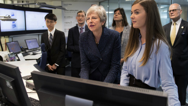 Theresa May observing machinery which converts carbon dioxide into oxygen on the day she announced plans to eliminate the UK's net emissions.
