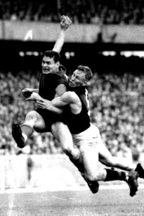 An iconic image of Barassi kicking a brilliant goal while being tackled by Essendon’s Bob Suter in 1957.