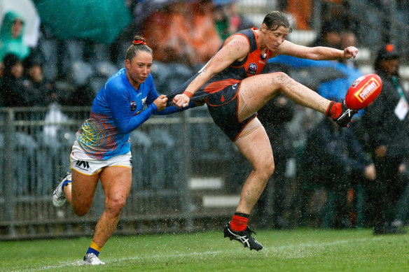 Giant downpour: Cora Staunton of the GWS competes with Yacqui Yorston in horror conditions.