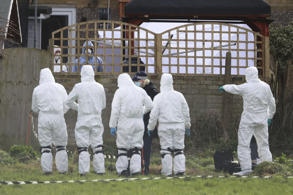 Forensic officers conduct a search behind a house in Deal, south-east England.
