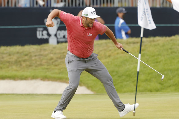 Jon Rahm celebrates making a putt for birdie on the 18th.